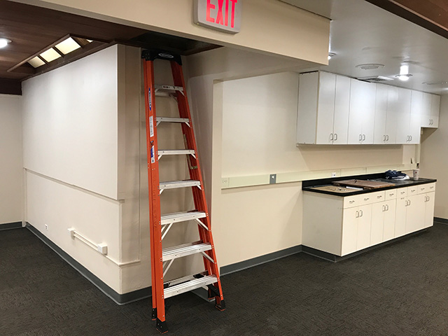 Employee break-room with sink and cabinets.