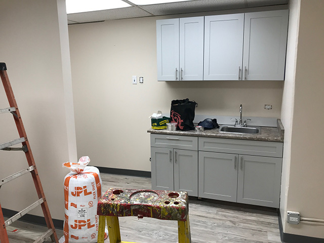 Employee break-room with sink and cabinets.